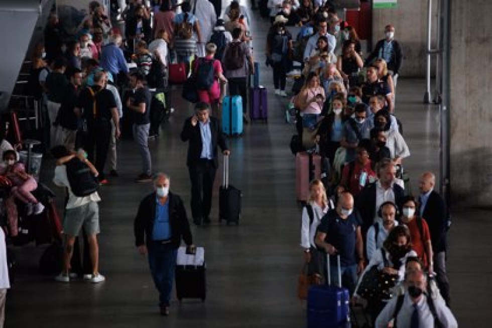 Varias personas esperan la cola de los taxis en la Terminal 4 (T4) del aeropuerto Adolfo Su&aacute;rez Madrid-Barajas.