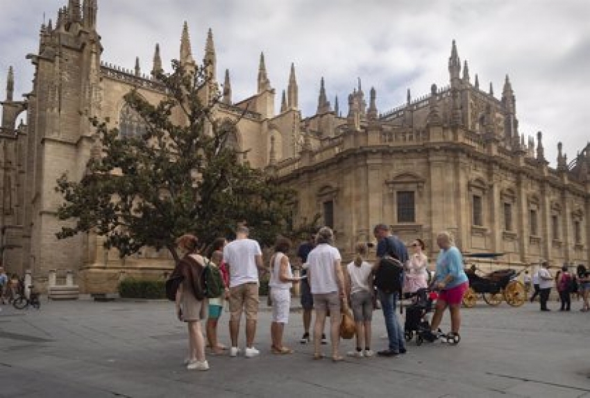 Un grupo de turistas ante la fachada de la Catedral. A 11 de agosto de 2022, en Sevilla (Andaluc&iacute;a, Espa&ntilde;a).