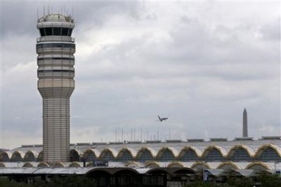 Un avión pasa frente a la torre de control aéreo en el aeropuerto Ronald Reagan en Washington el 10 de agosto del 2015. Los horarios de trabajo de los controladores aéreos suelen provocar fatiga crónica que reducen su sentido de alerta y ponen en peligro la seguridad del tráfico aéreo nacional, según un estudio que el gobierno ha mantenido en secreto durante casi cuatro años, reportó la AP ese mismo día.