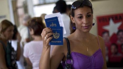 Una mujer muestra su pasaporte y el de su hijo al dejar una oficina de inmigraci&oacute;n en La Habana, Cuba. 