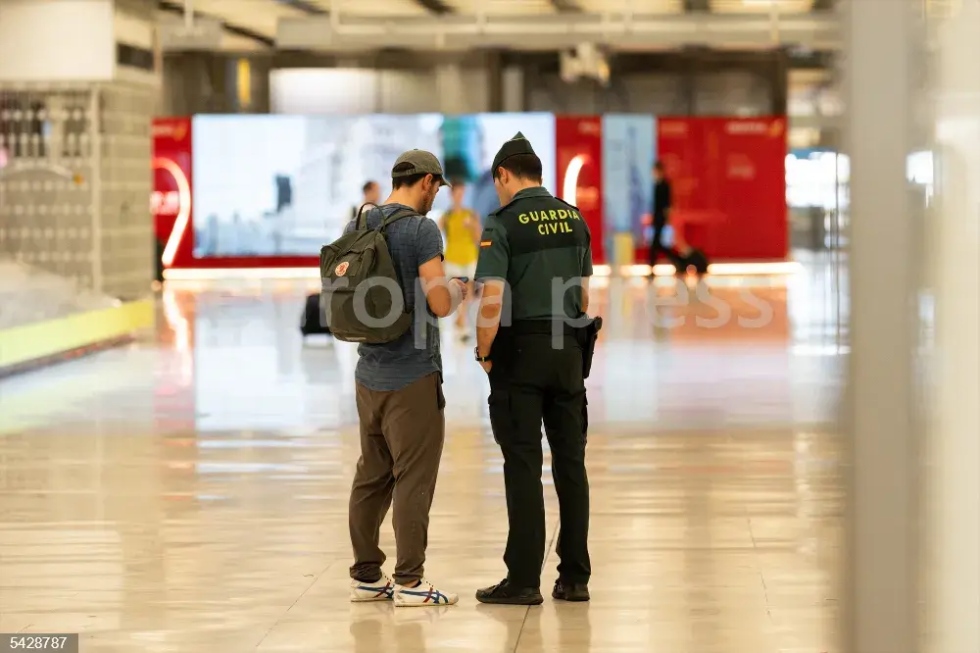 Un pasajero habla con una agente de la Guardia Civil en la T4 el Aeropuerto Adolfo Su&aacute;rez Madrid-Barajas
