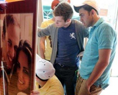 Unos turistas firman una tarjeta con motivo de la boda real brit&aacute;nica en el museo Madame Tussauds de Hollywood